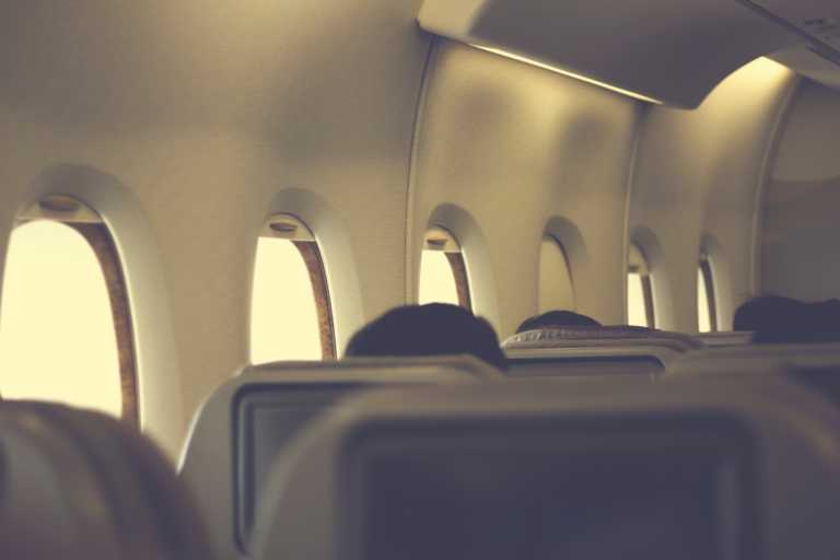 Cabine de avião com luzes apagadas durante a decolagem, ilustrando o protocolo de segurança adotado pelas companhias aéreas.