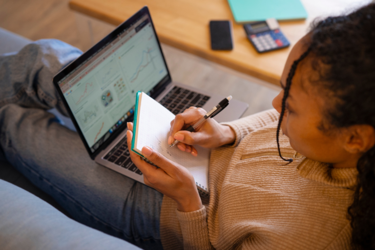 Pessoa estudando em casa com celular e notebook, aproveitando 15 minutos livres para aprender algo novo.